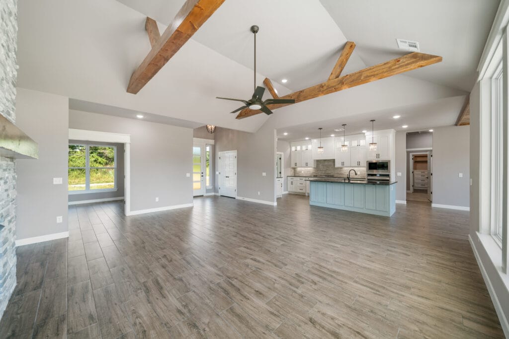 Cozy living room space with large windows and custom finishes by Mahogany Homes.