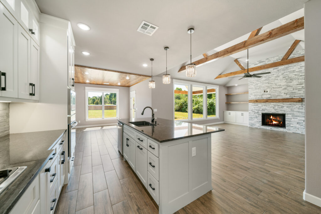 Contemporary kitchen design with a large island and modern lighting by Mahogany Homes.