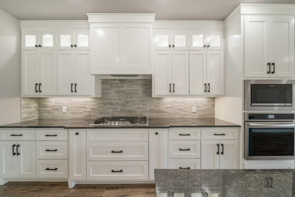 Gourmet kitchen with a clean, minimalist design and top-tier appliances by Mahogany Homes.