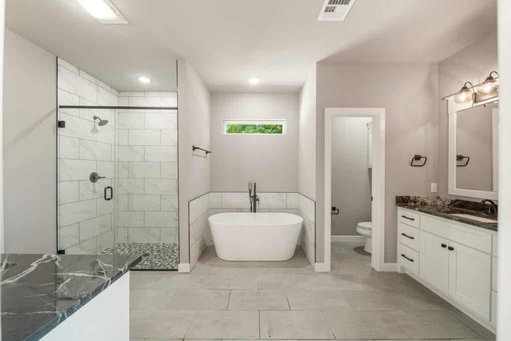 Luxury bathroom with a rain shower, custom countertops, and modern design elements by Mahogany Homes.