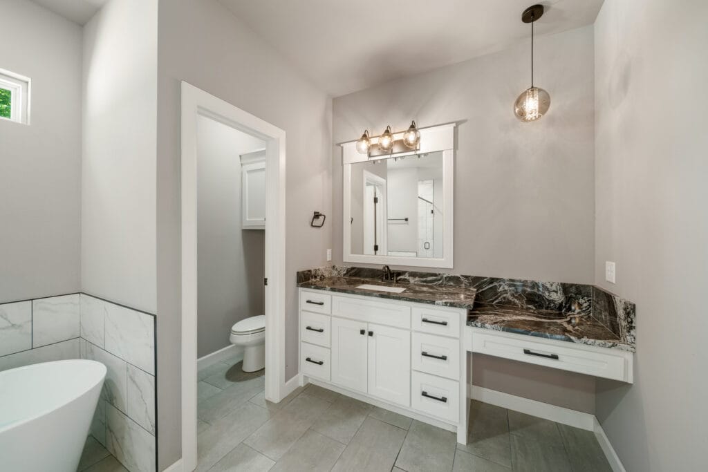 Sophisticated bathroom with a large soaking tub and custom marble finishes by Mahogany Homes.