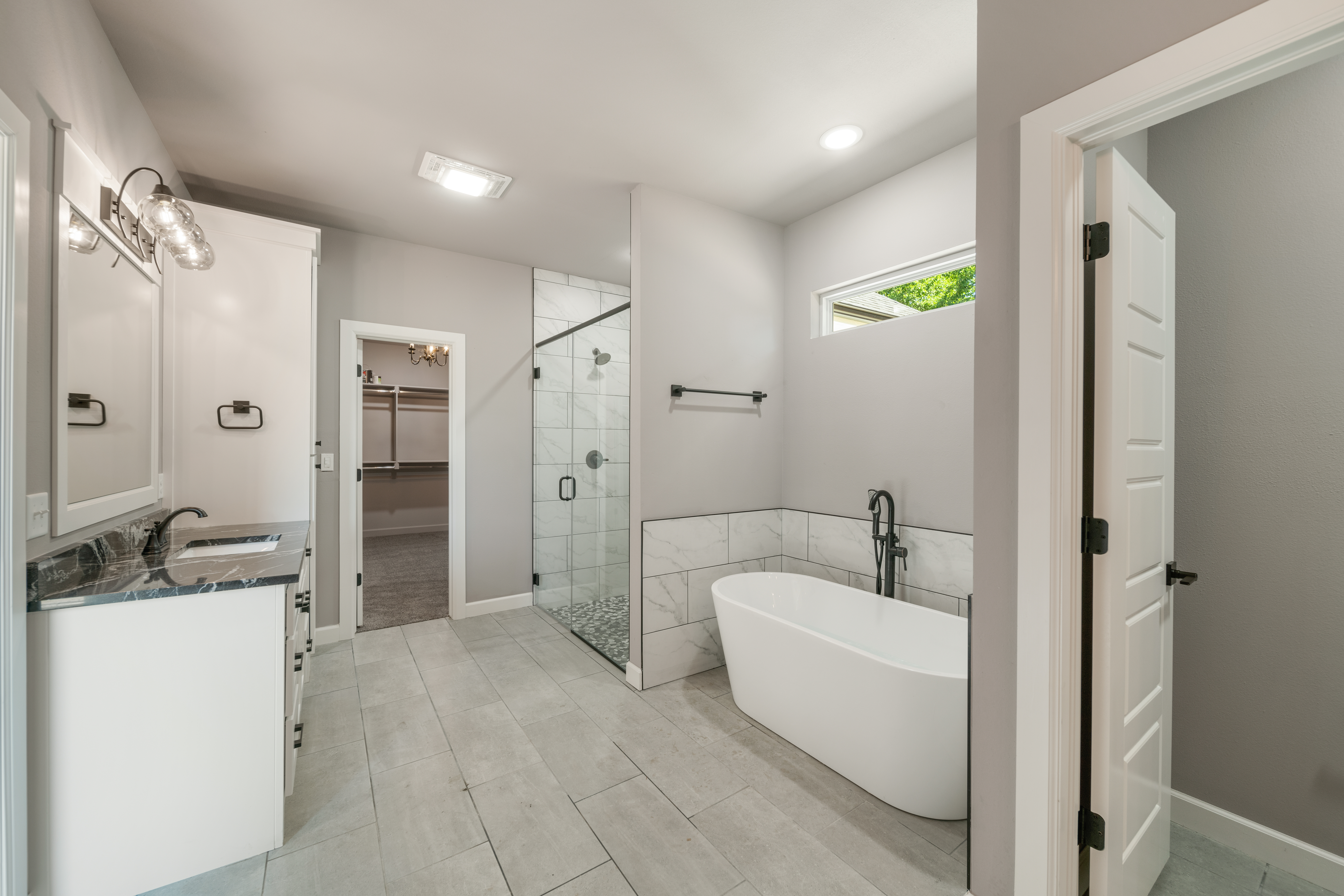 Beautiful bathroom with a double vanity, custom mirrors, and a spacious walk-in shower by Mahogany Homes Tulsa.