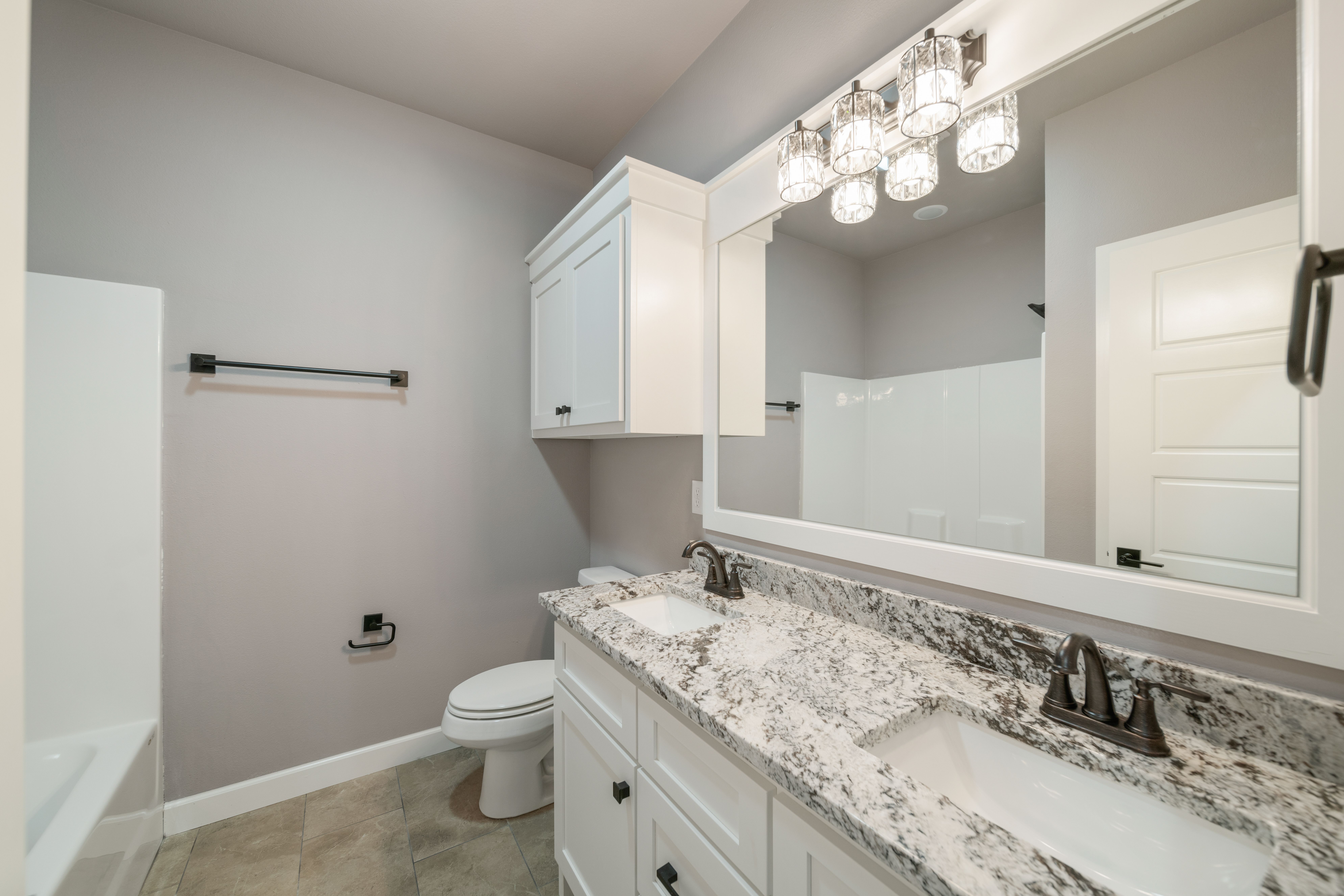 Bright and airy bathroom featuring a luxurious shower and custom sinks by Mahogany Homes Tulsa.