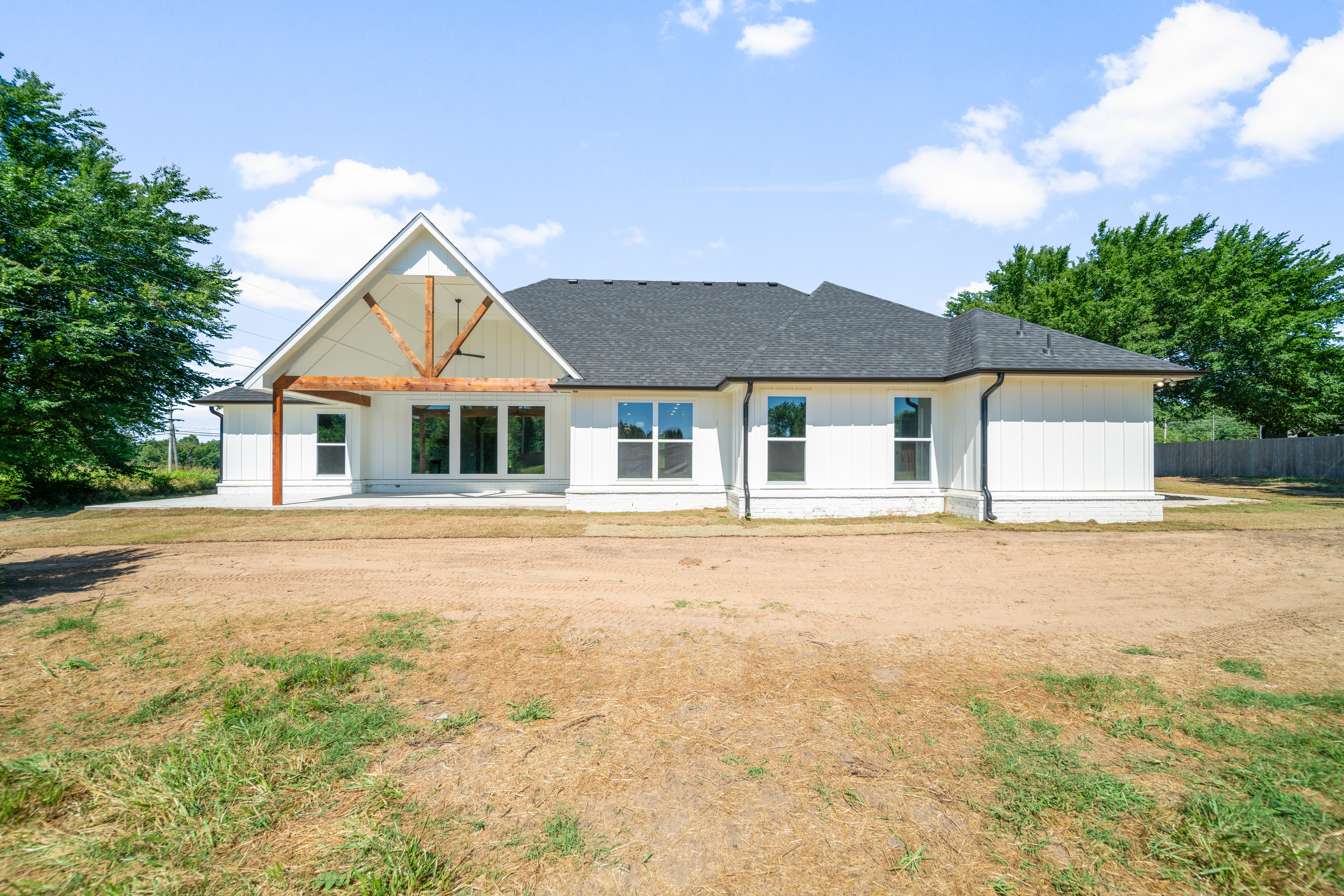 Contemporary home exterior with large windows and a welcoming porch by Mahogany Homes Tulsa.