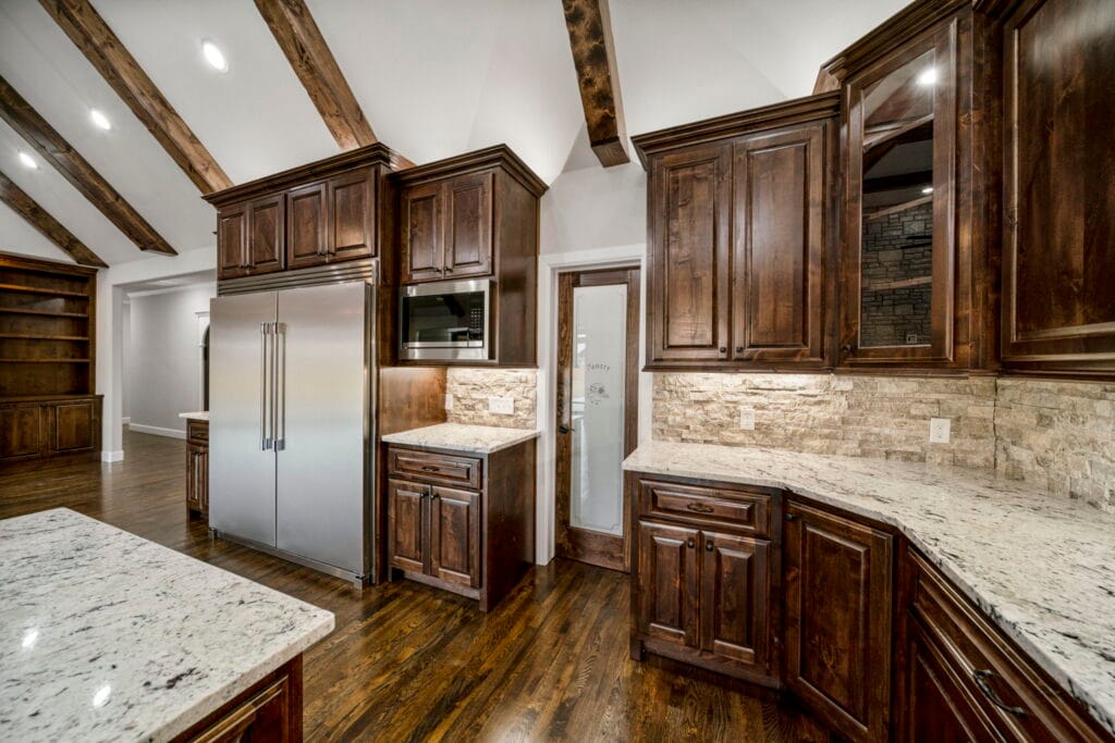 Open kitchen design with state-of-the-art appliances and sleek countertops by Mahogany Homes