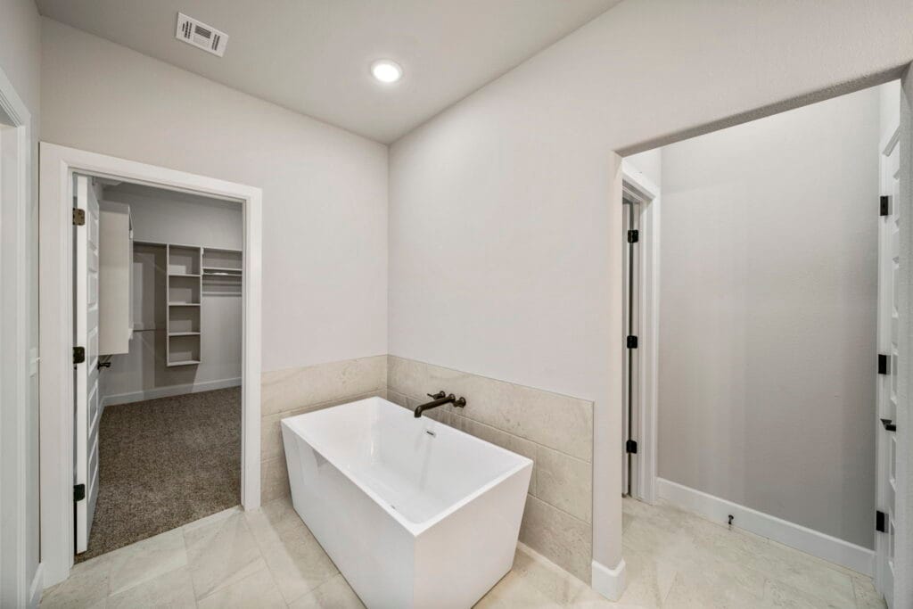 Bright and stylish bathroom with custom cabinetry and a designer walk-in shower by Mahogany Homes Tulsa.