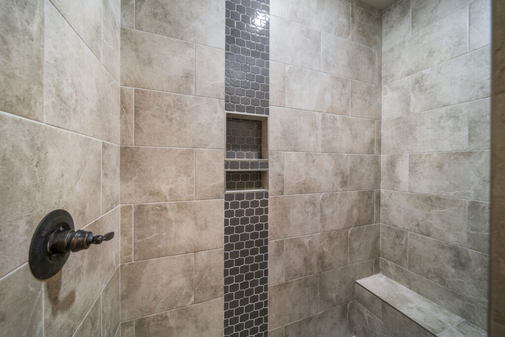 Contemporary bathroom with a spa-inspired design, featuring custom tile and elegant lighting by Mahogany Homes.