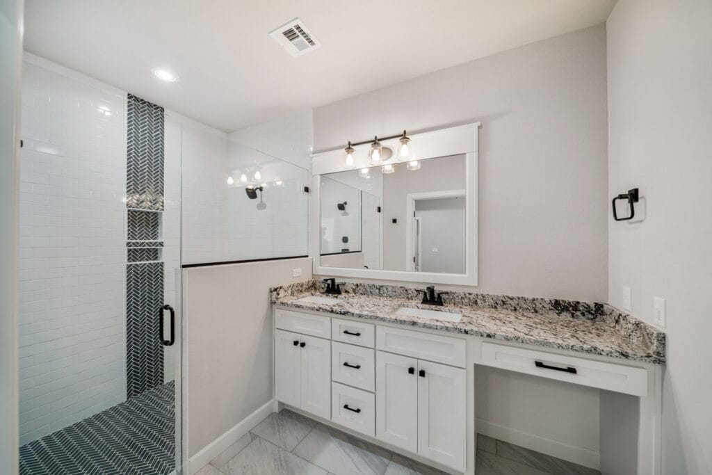 Sleek bathroom design with a double vanity and high-end finishes by Mahogany Homes Tulsa.